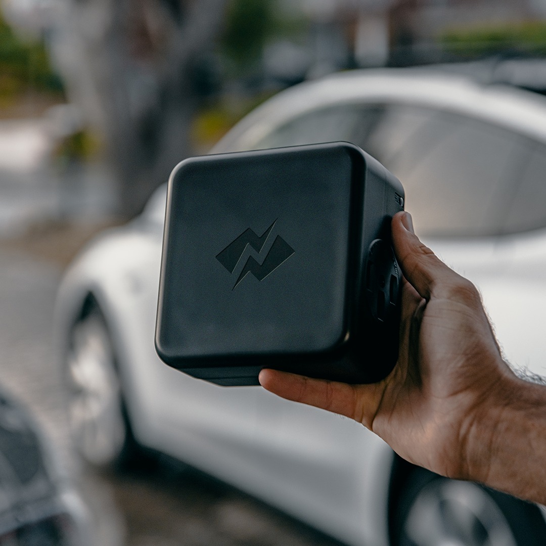 NeoCharge Smart Splitter product photograph beside an electric vehicle