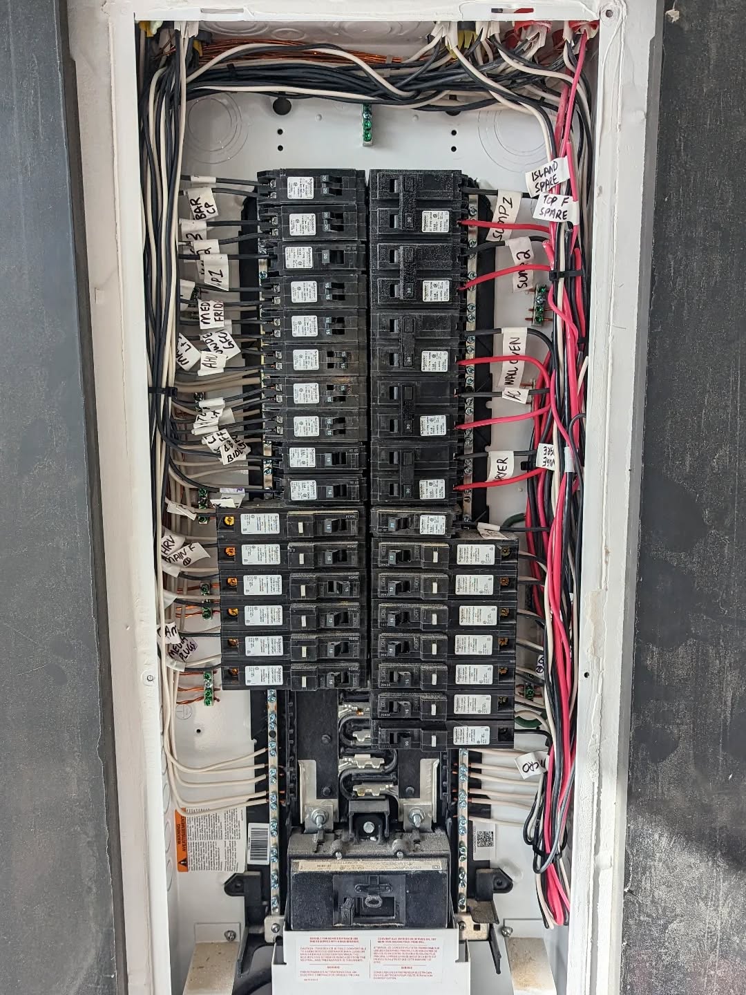 Open electrical panel showing wiring, breakers and circuit labels
